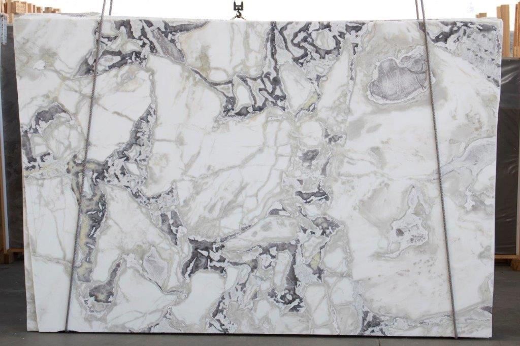 A large white marble slab is hanging from a rope.