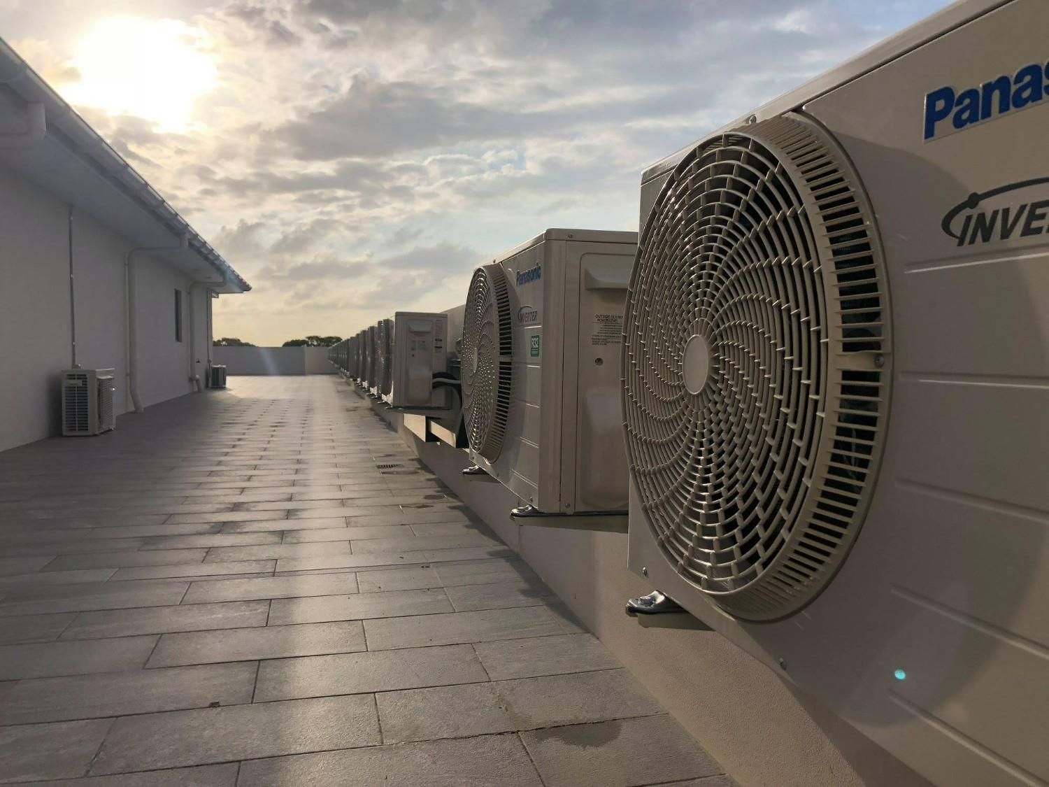 A row of Panasonic air conditioning units on a rooftop, with a cloudy sky in the background. — Careda Air in Saint Georges Basin, NSW 