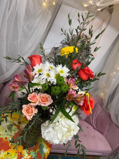 Bouquet of burgundy and white roses on a wooden table in a bright room