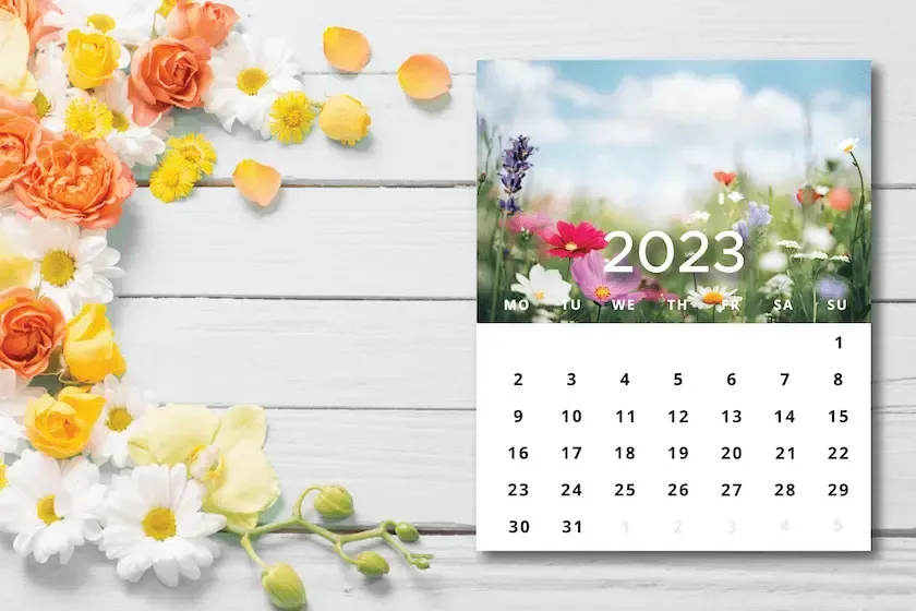 A calendar with flowers on a wooden table