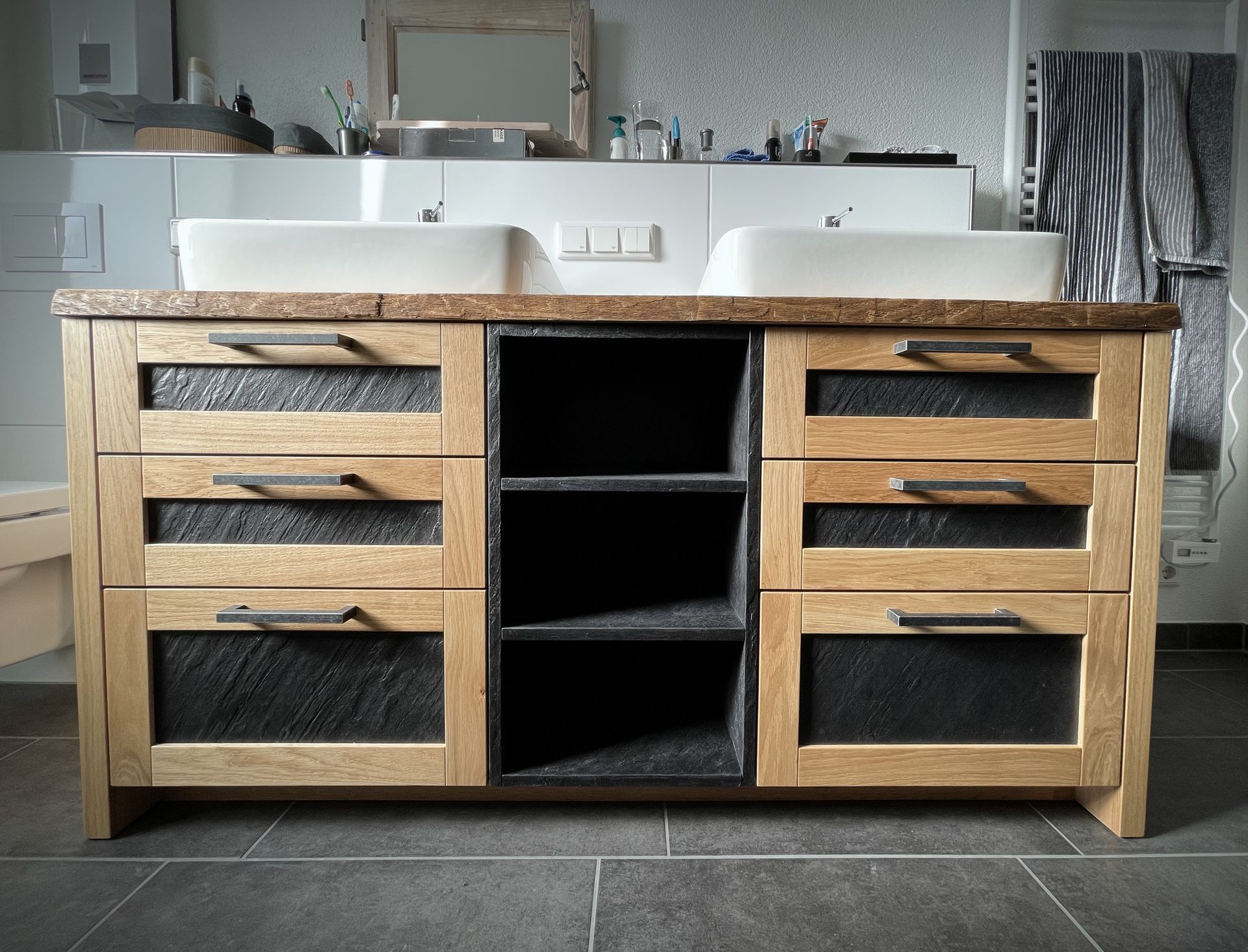 Moderner Badezimmerschrank mit Doppelwaschbecken, Holzschränken und schwarzem Fliesenboden