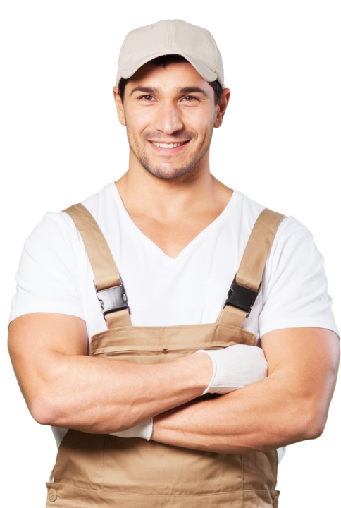 A man wearing overalls and a hat is standing with his arms crossed.