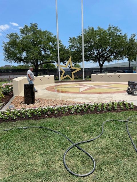 A man is standing in front of a large star in a park.