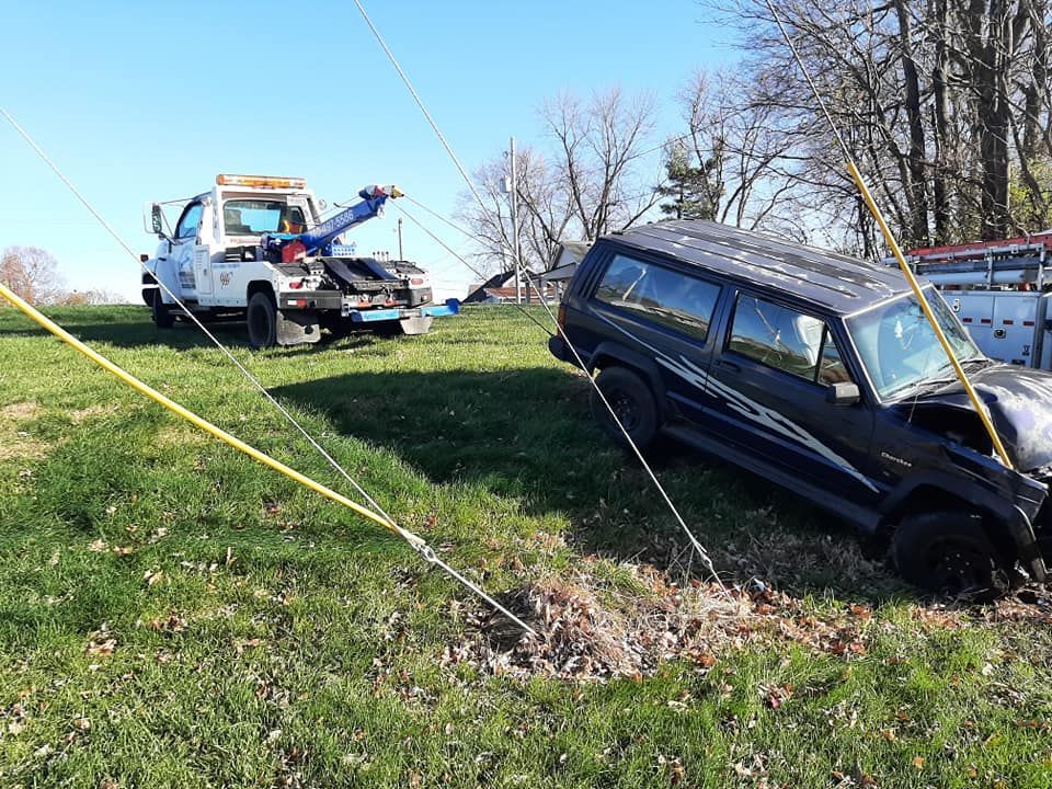 A tow truck is towing a car that has fallen off the road.