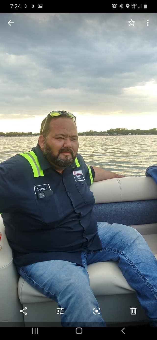 A man is sitting on a boat in the water.