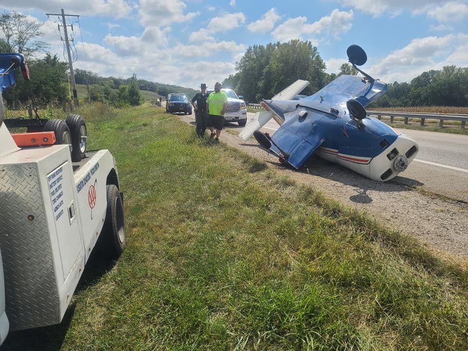A small plane has crashed on the side of the road.