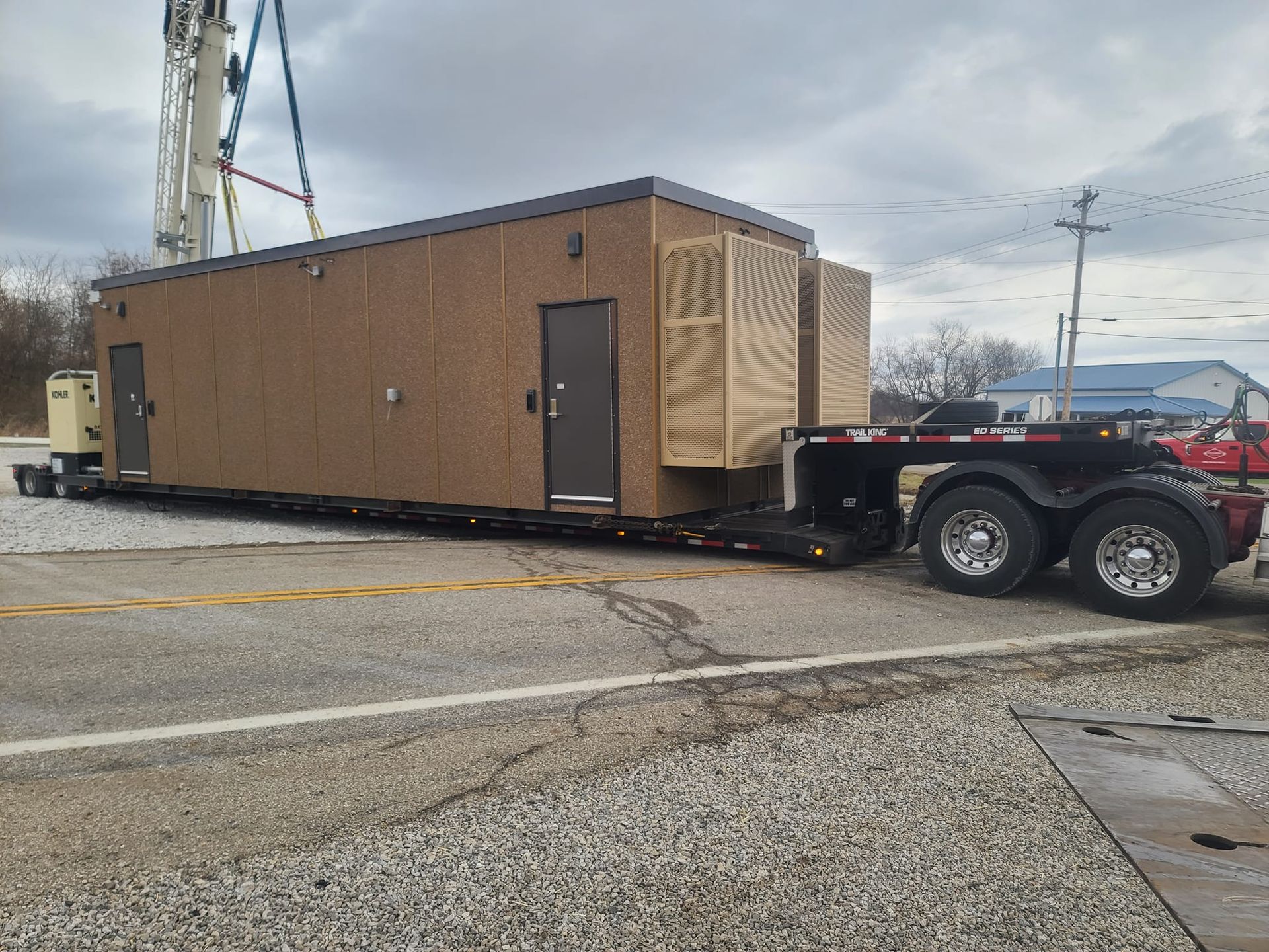 A trailer with a container on it is being lifted by a crane.