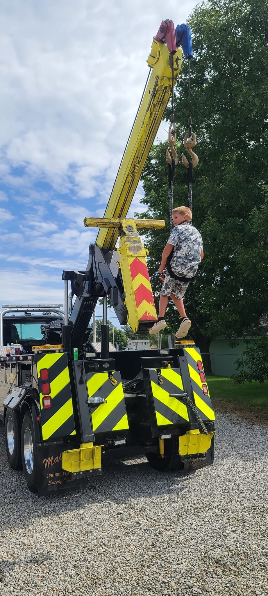 A man is sitting on top of a yellow crane.