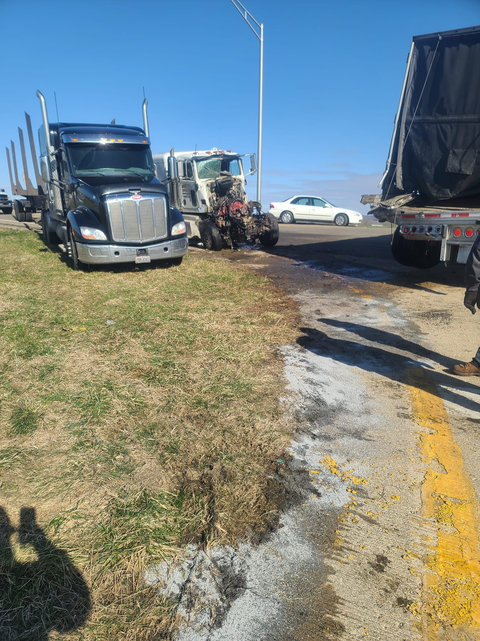 Two semi trucks are parked next to each other on the side of the road.