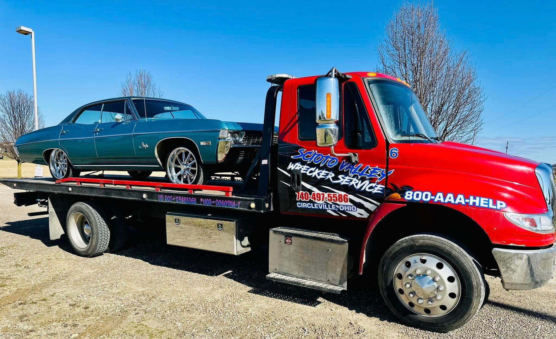 A blue car is being towed by a tow truck