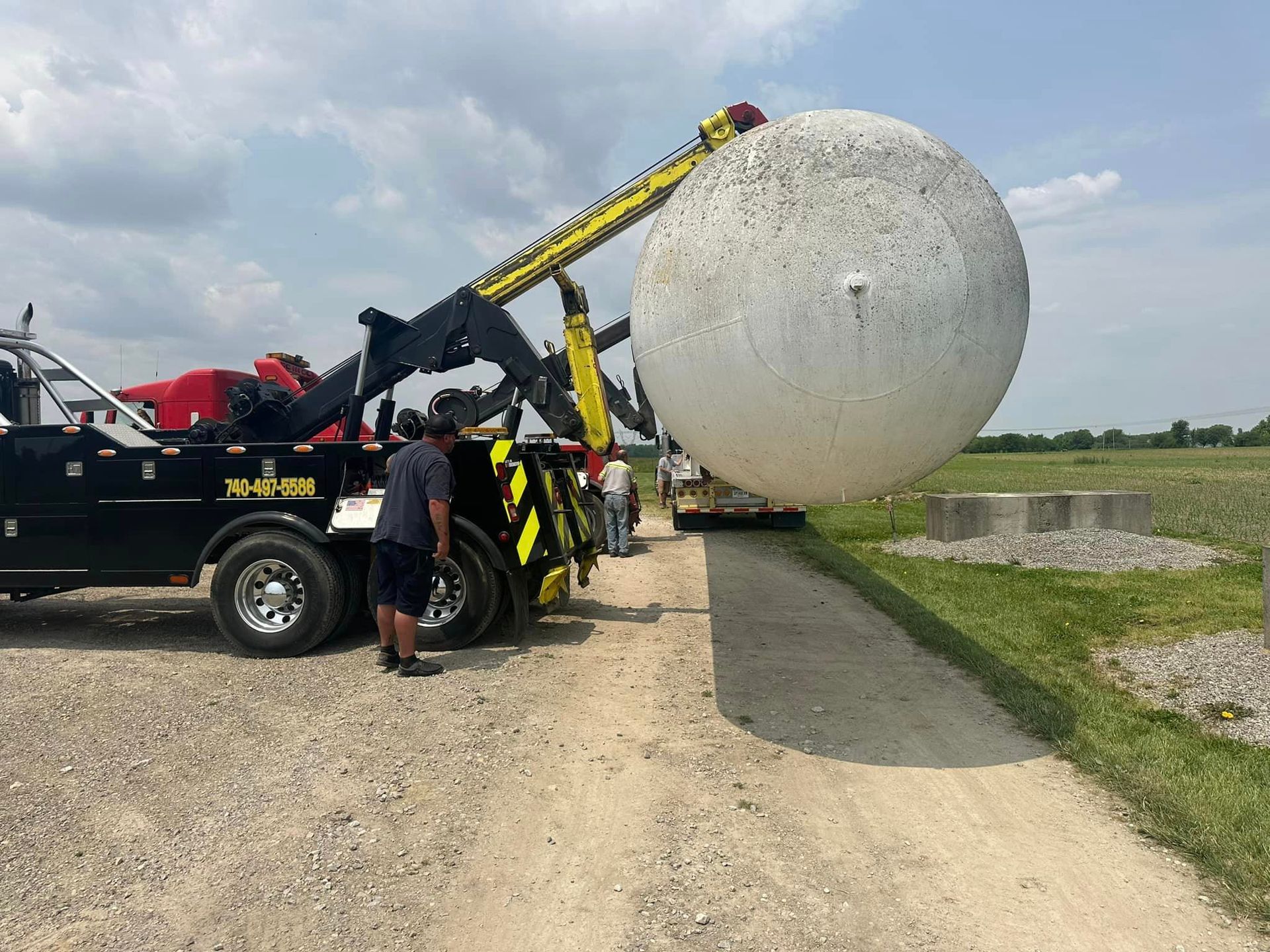 A large white ball is being lifted by a tow truck.