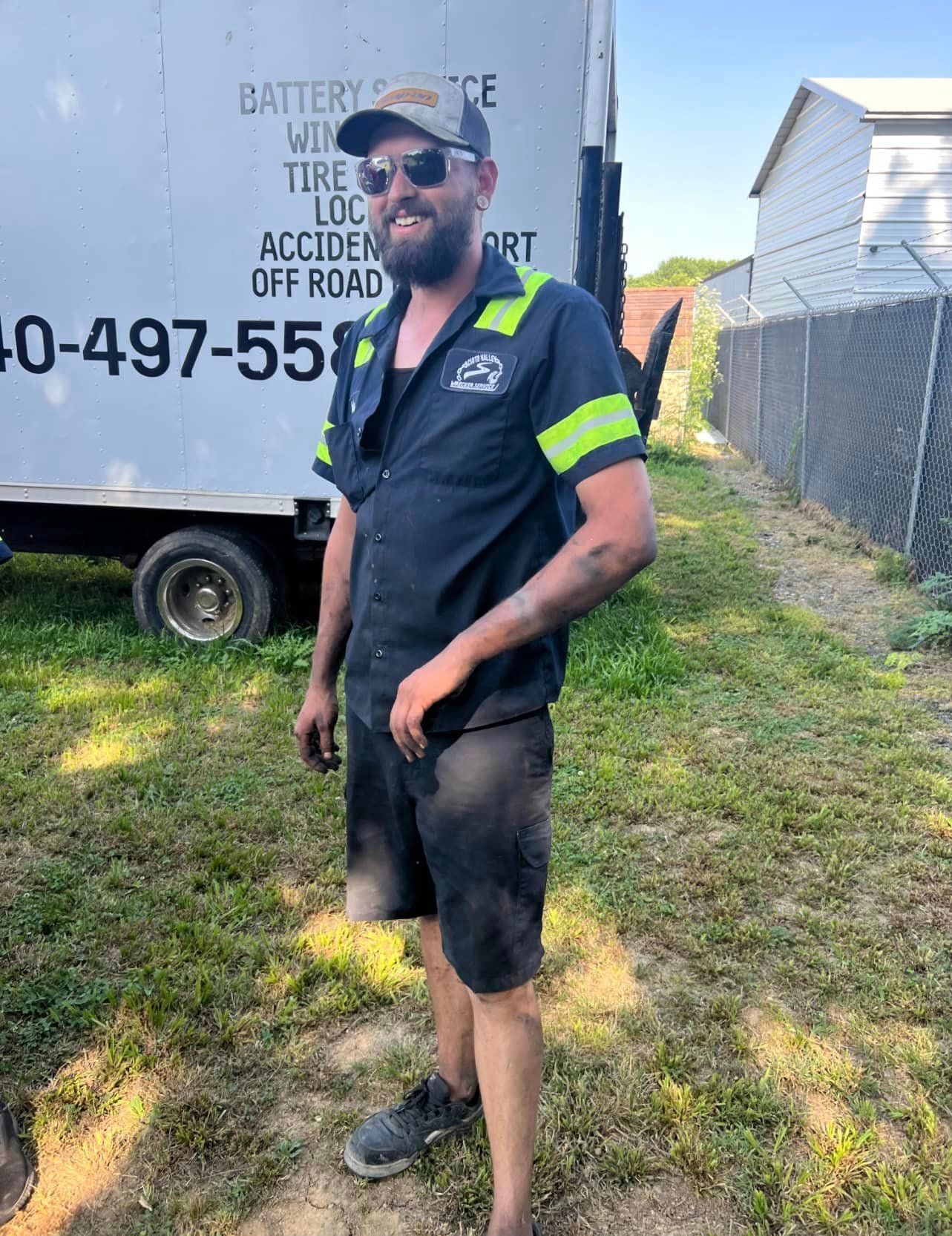 A man is standing in front of a white truck.