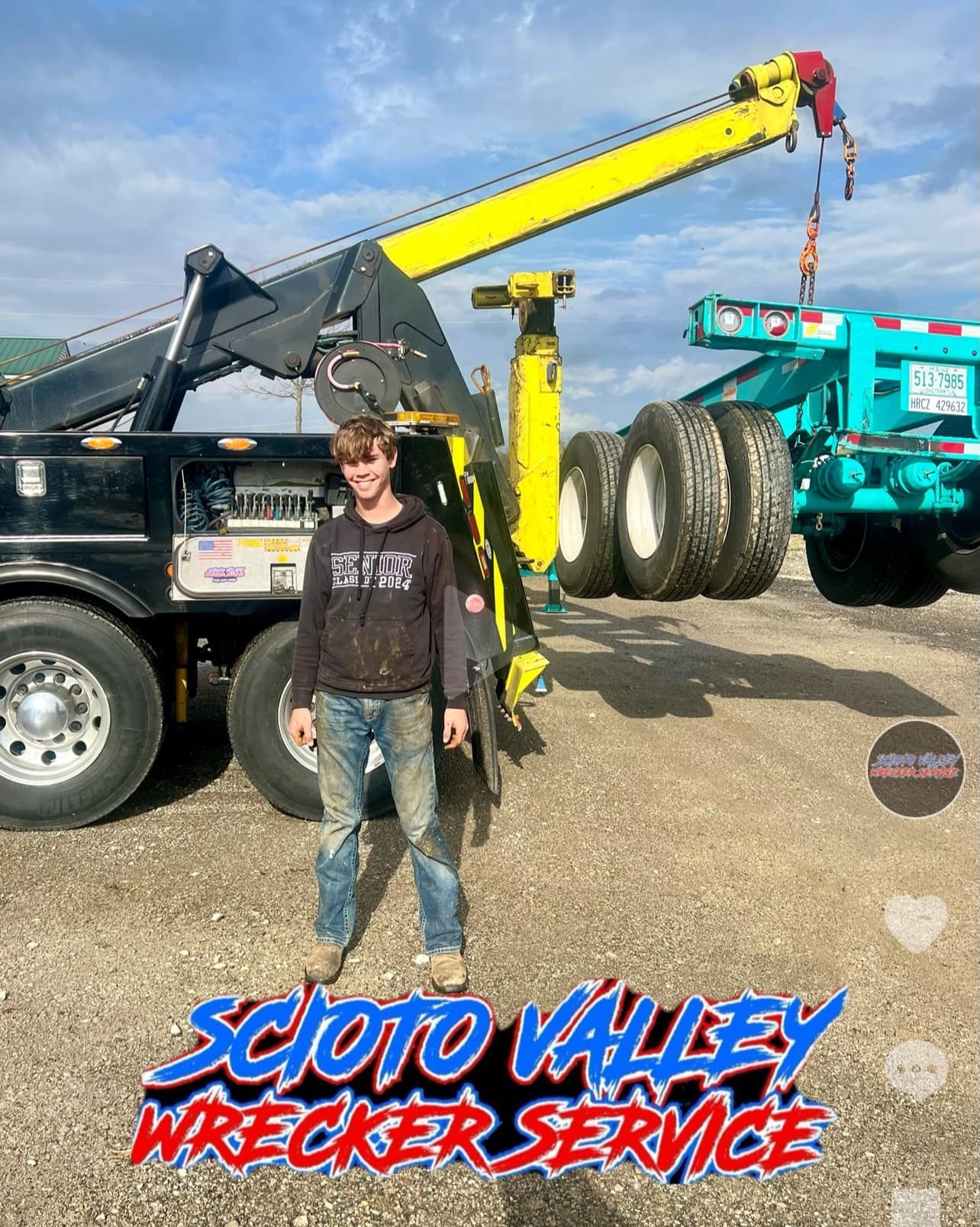 A man is standing in front of a tow truck.