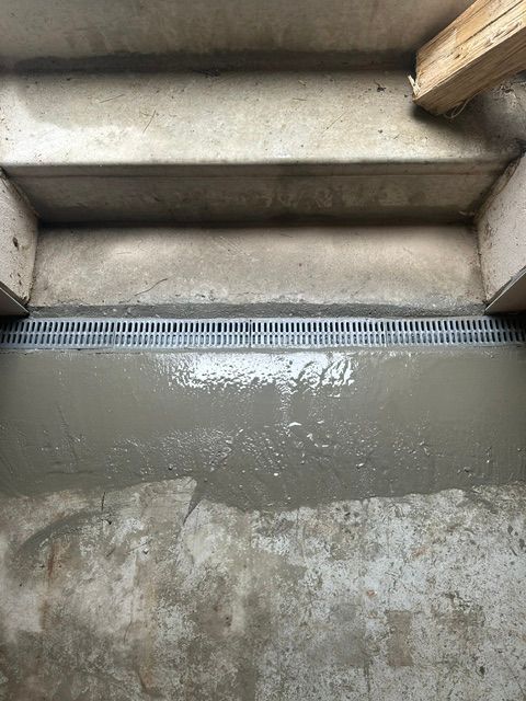 Concrete steps with a wet landing and a grated drain at the bottom