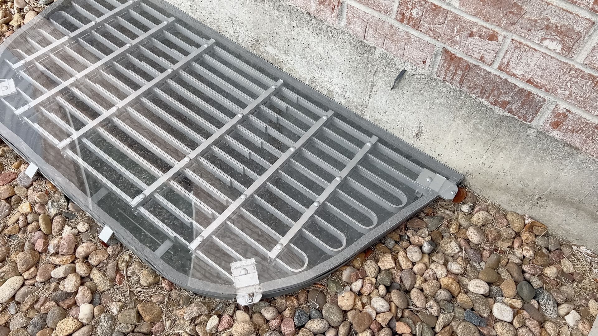 Concrete basement floor with a long drain along the wall and exposed utility panels.
