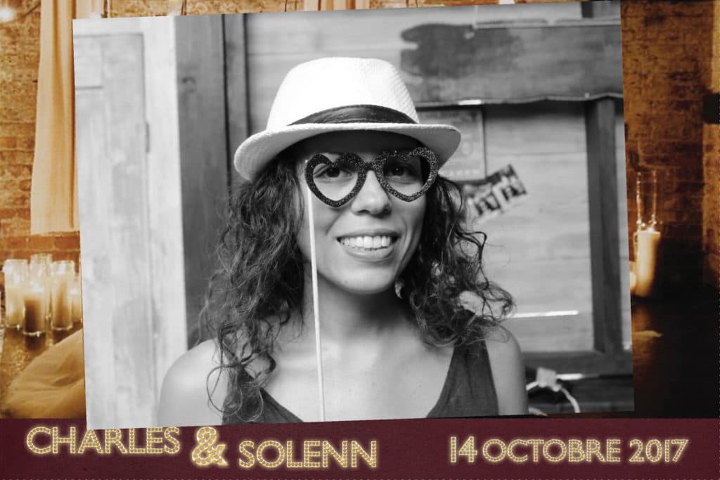 A black and white photo of a woman wearing a hat and glasses