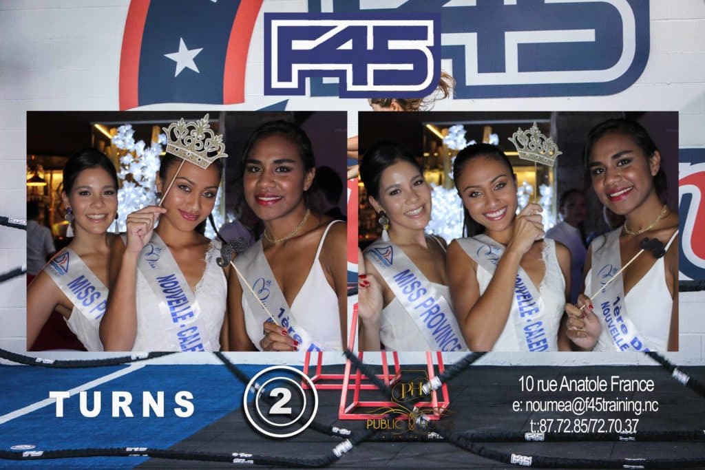 A group of women standing in front of a sign that says turns 2