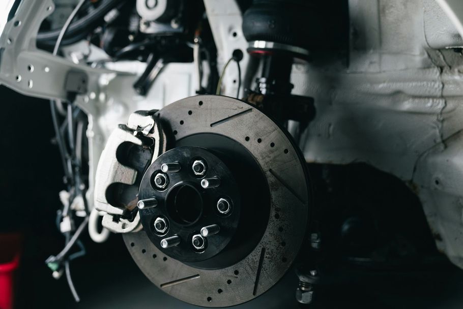 Close-up of a car’s front brake rotor and caliper inside the wheel well.
