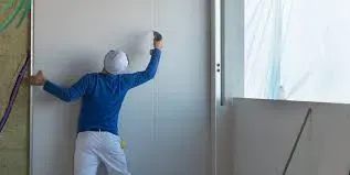 A Person Installing Drywall — McNamara's Frames & Trusses In Forster, NSW
