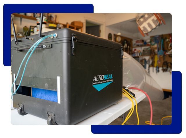 Black AeroSeal duct sealing machine on a table in a garage.