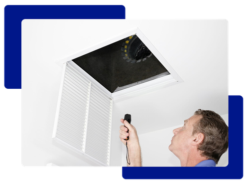 Man inspecting an air vent with a flashlight in a white room.