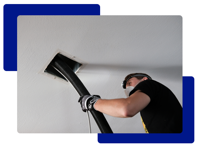 Person vacuuming a ceiling air vent.