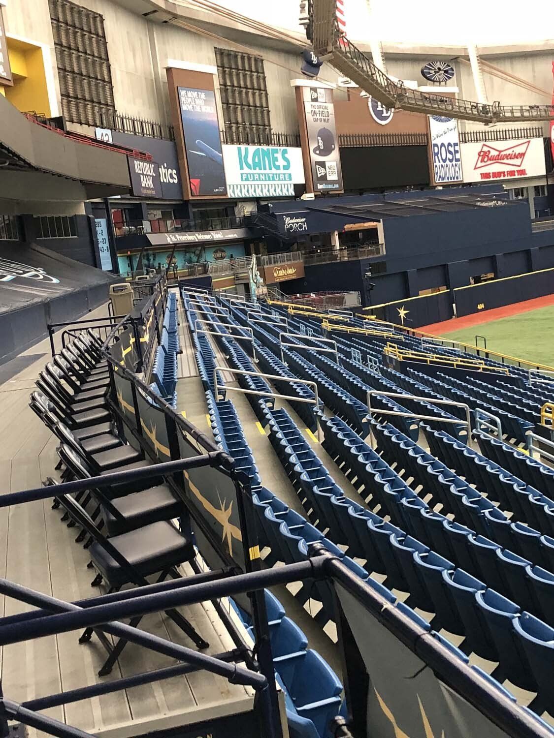 Empty baseball stadium seats, blue and black. Signage, upper deck.