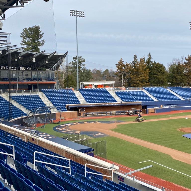 Baseball field with blue seating, overcast sky.