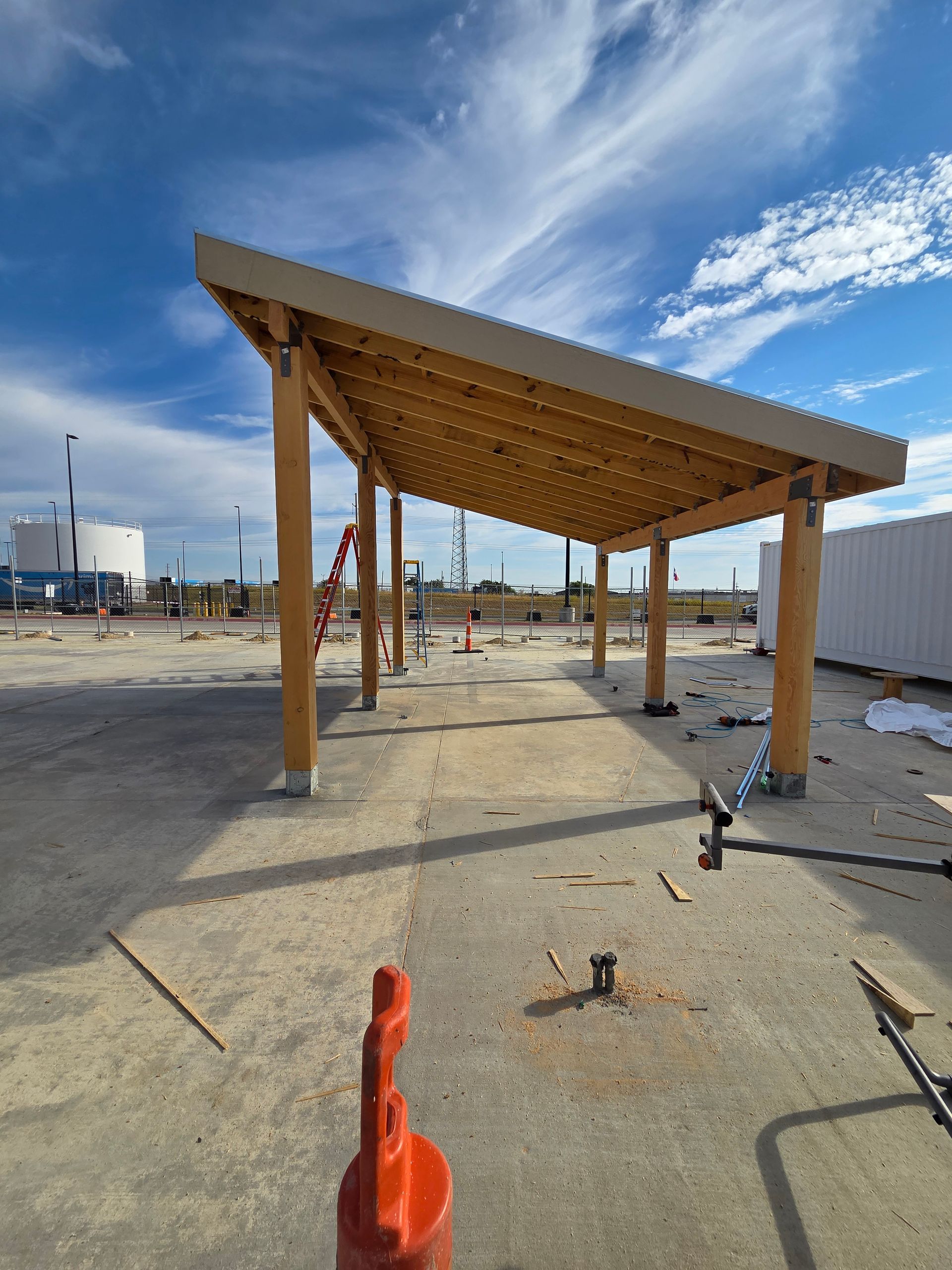 Wooden canopy under construction with blue sky background.