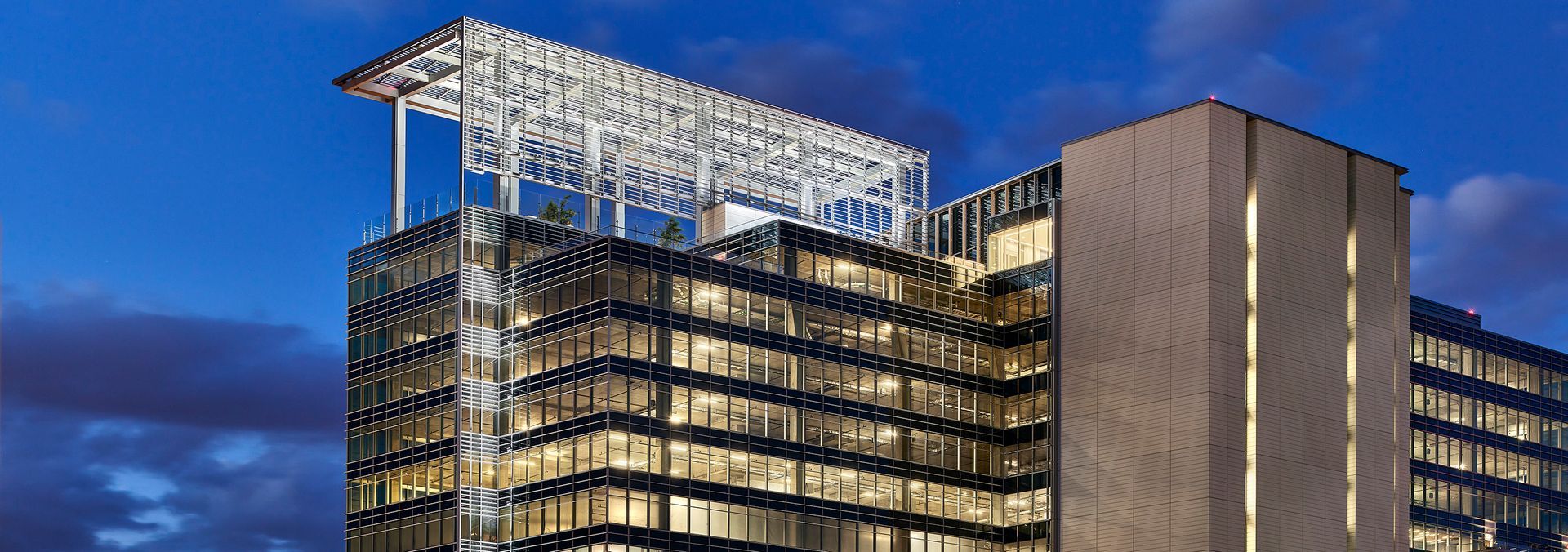 Exterior on Rooftop of a building with a metal trellis structure. Cloudy sky above.