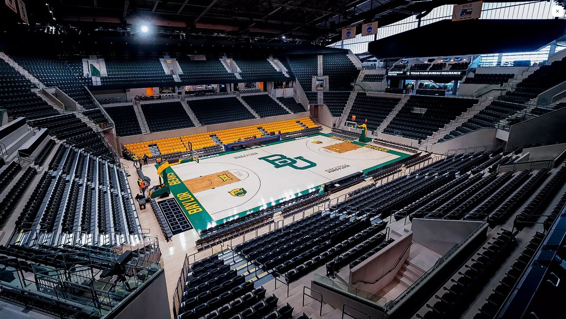 Basketball court inside Ferrell Center, Baylor University. Green and gold court with seating.
