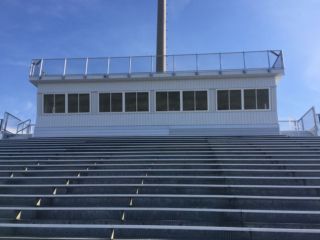 Bleachers leading to a press box at a stadium with a blue sky background.