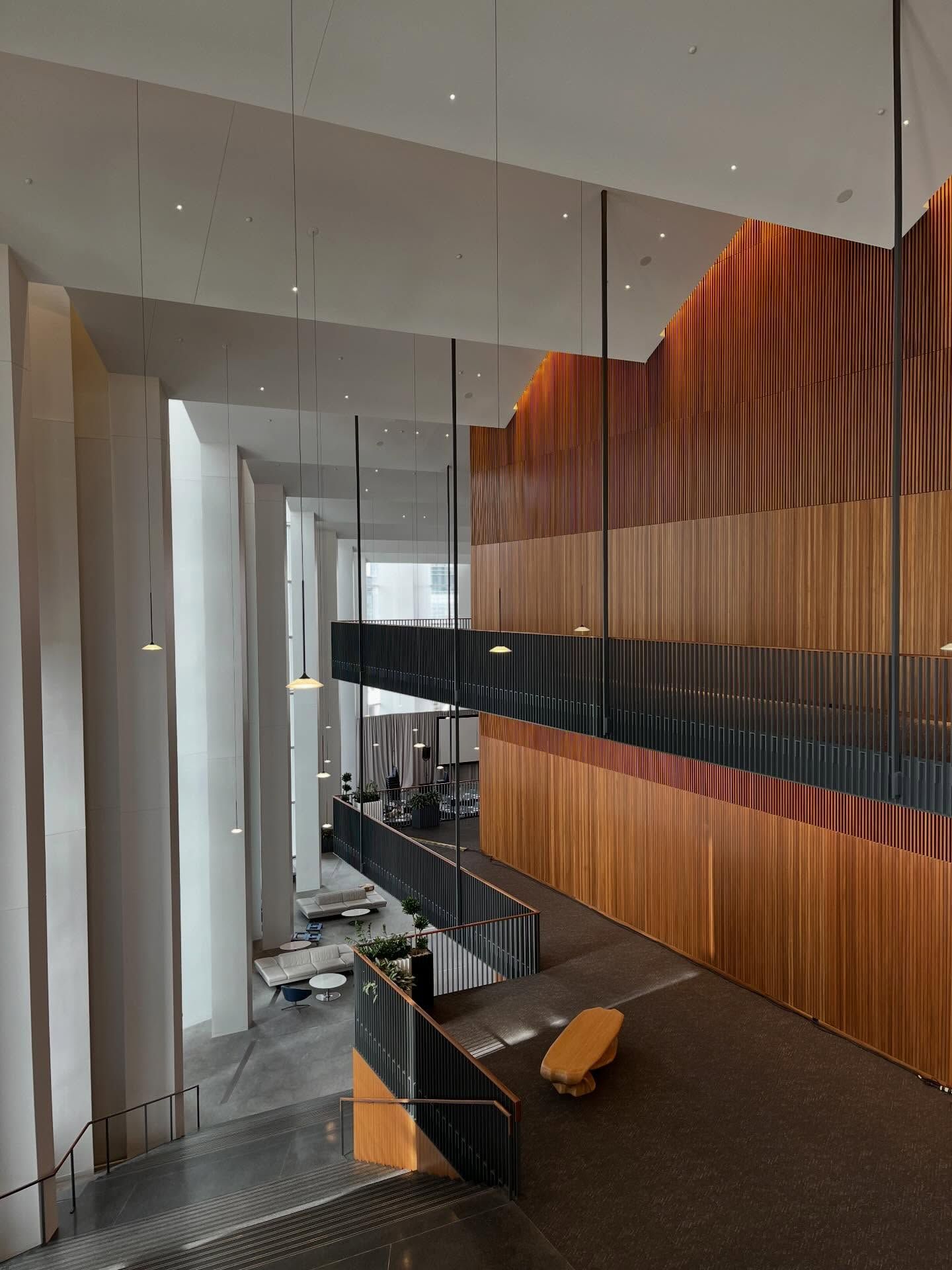 Modern interior with wood paneling and stairs leading to a seating area.