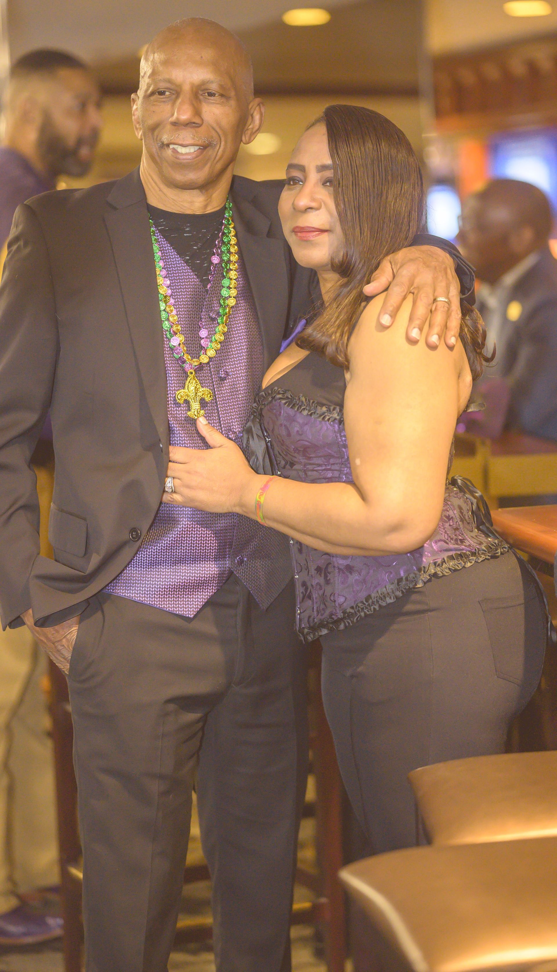 A man and a woman are posing for a picture in a bar.