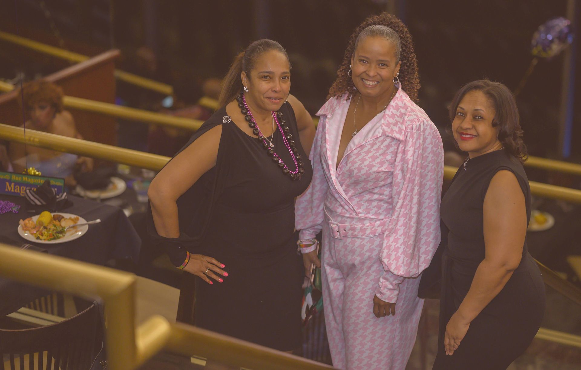 Three women are posing for a picture together in a dark room.
