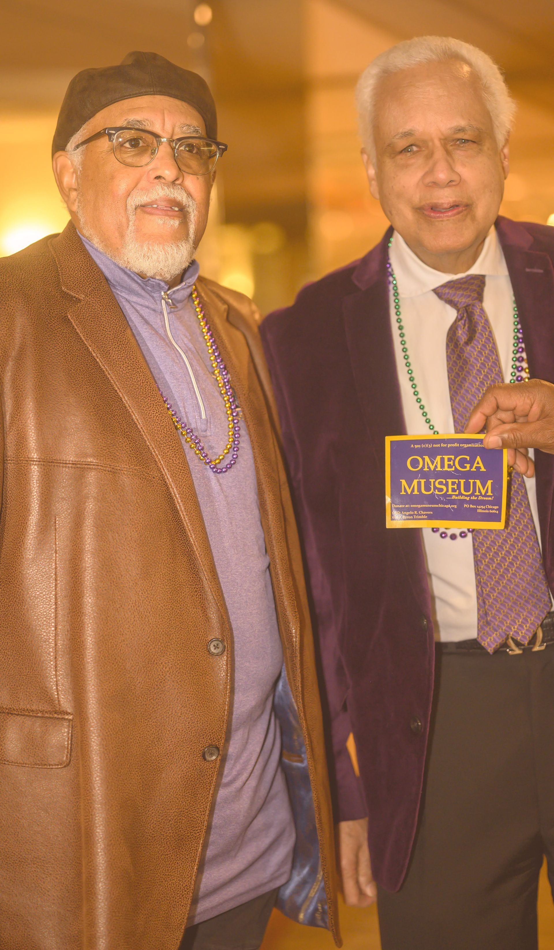 Two men are standing next to each other and one of them is wearing a purple jacket.