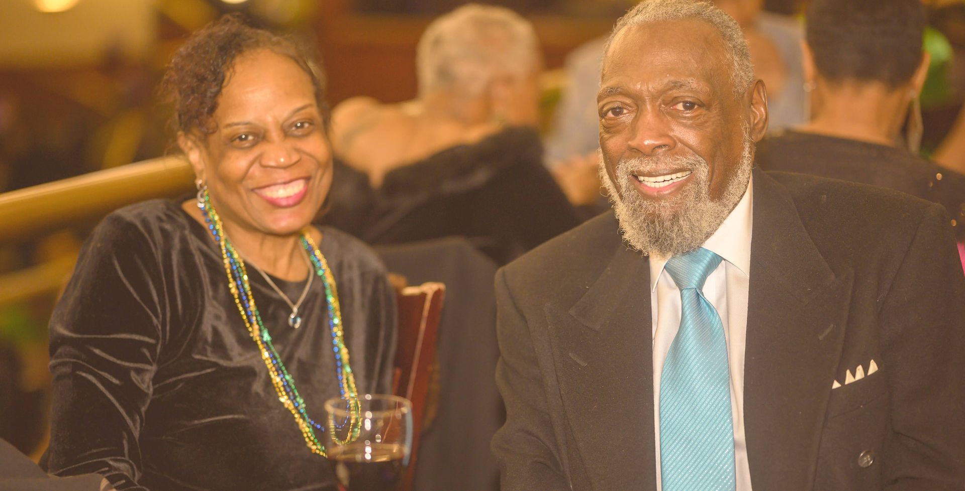 A man and a woman are sitting next to each other at a table and smiling.