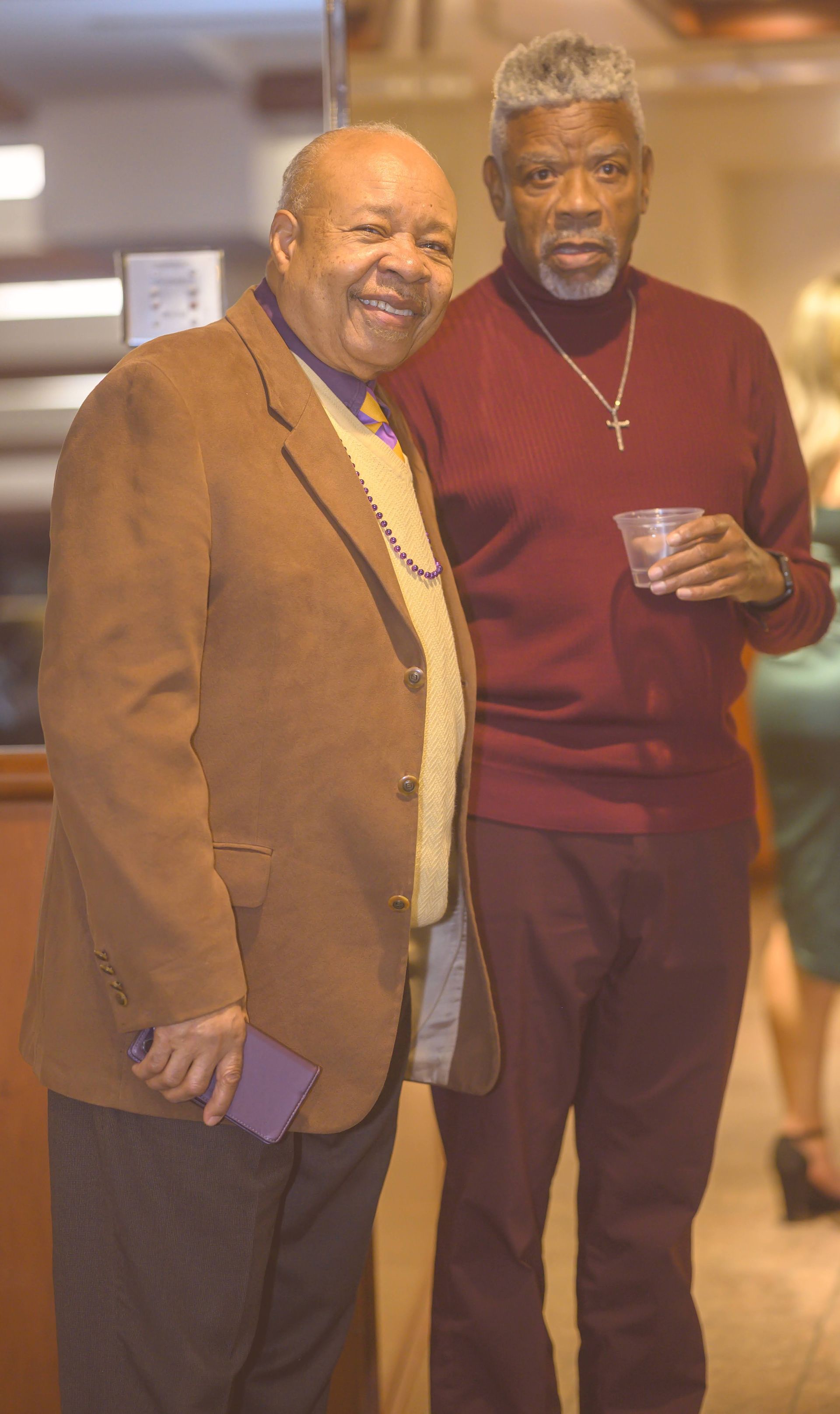 Two men are standing next to each other in a room.