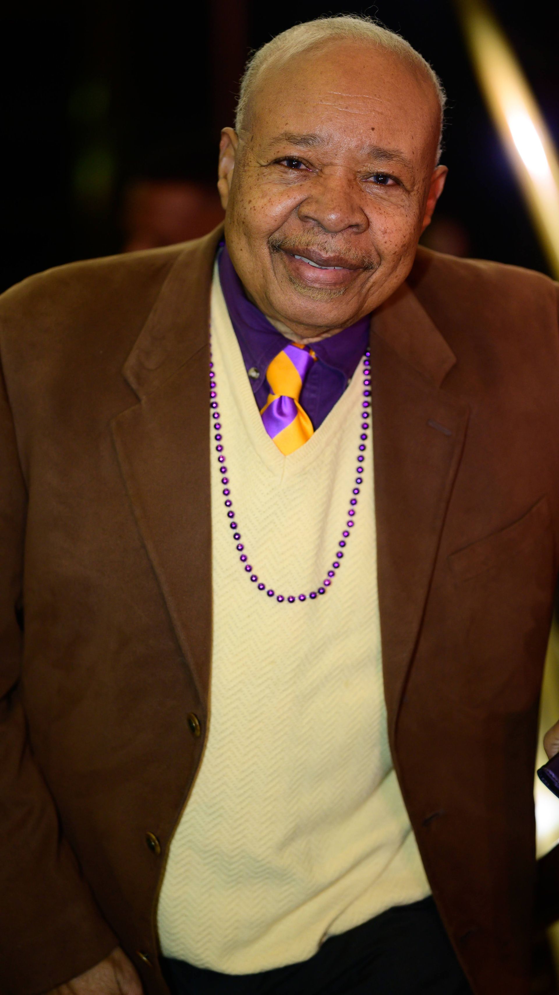 A man in a suit and tie is smiling for the camera.