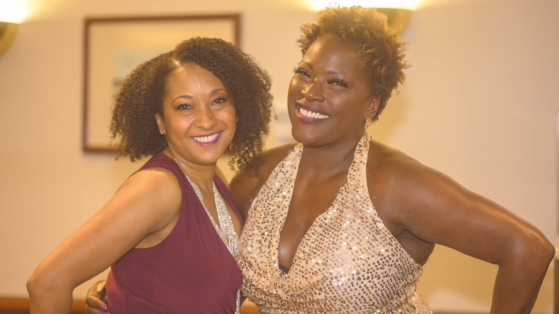 Two women are posing for a picture together and smiling for the camera.