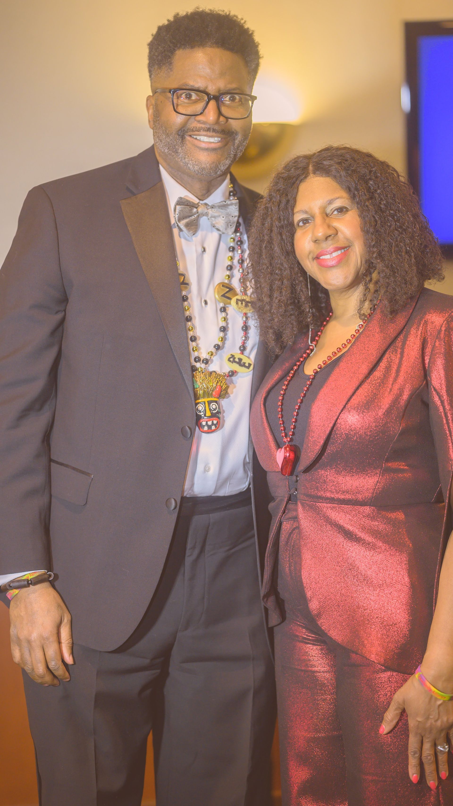 A man in a suit and a woman in a red dress are posing for a picture.