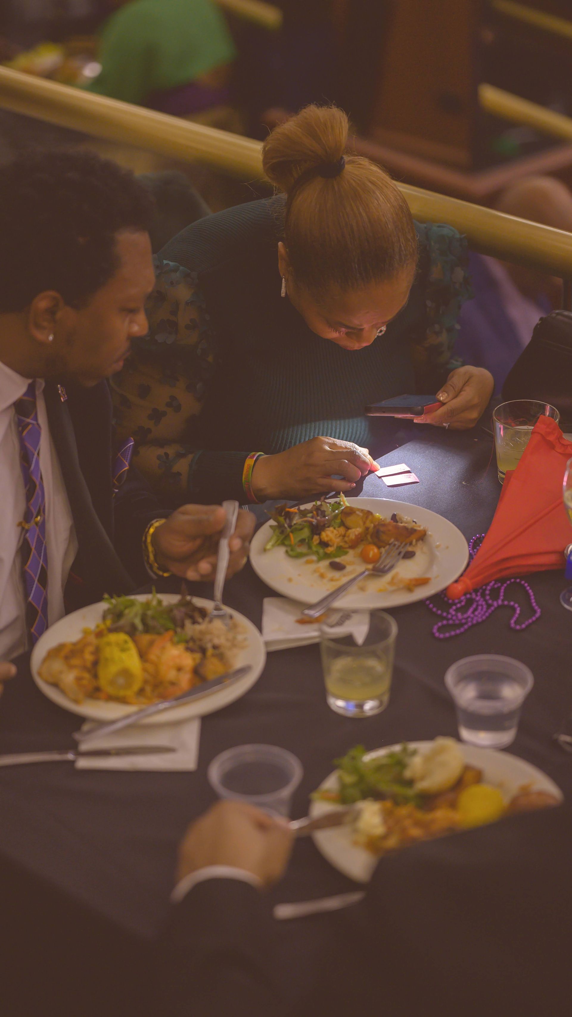 A man and a woman are sitting at a table eating food.