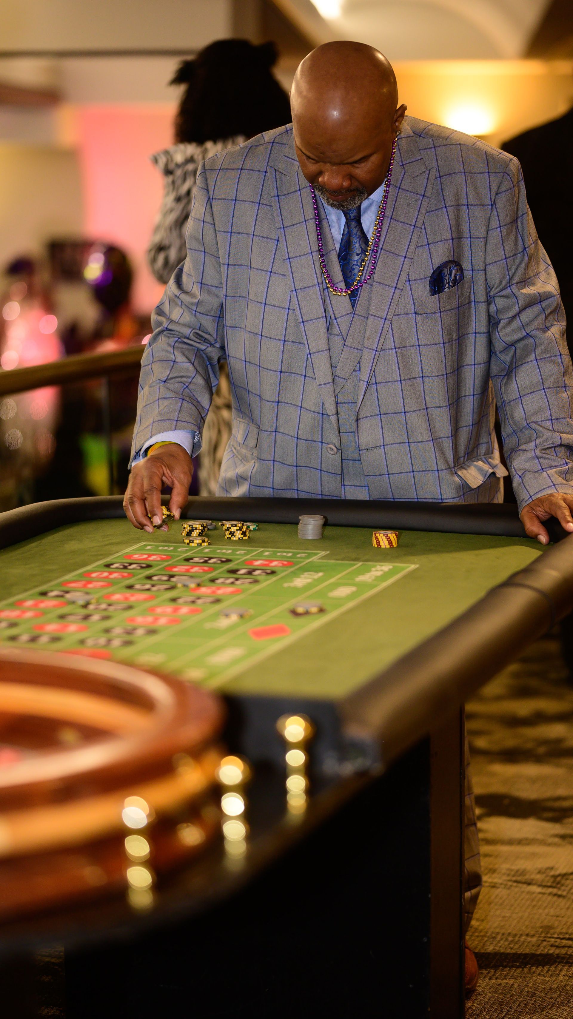 A man in a suit is playing roulette in a casino.