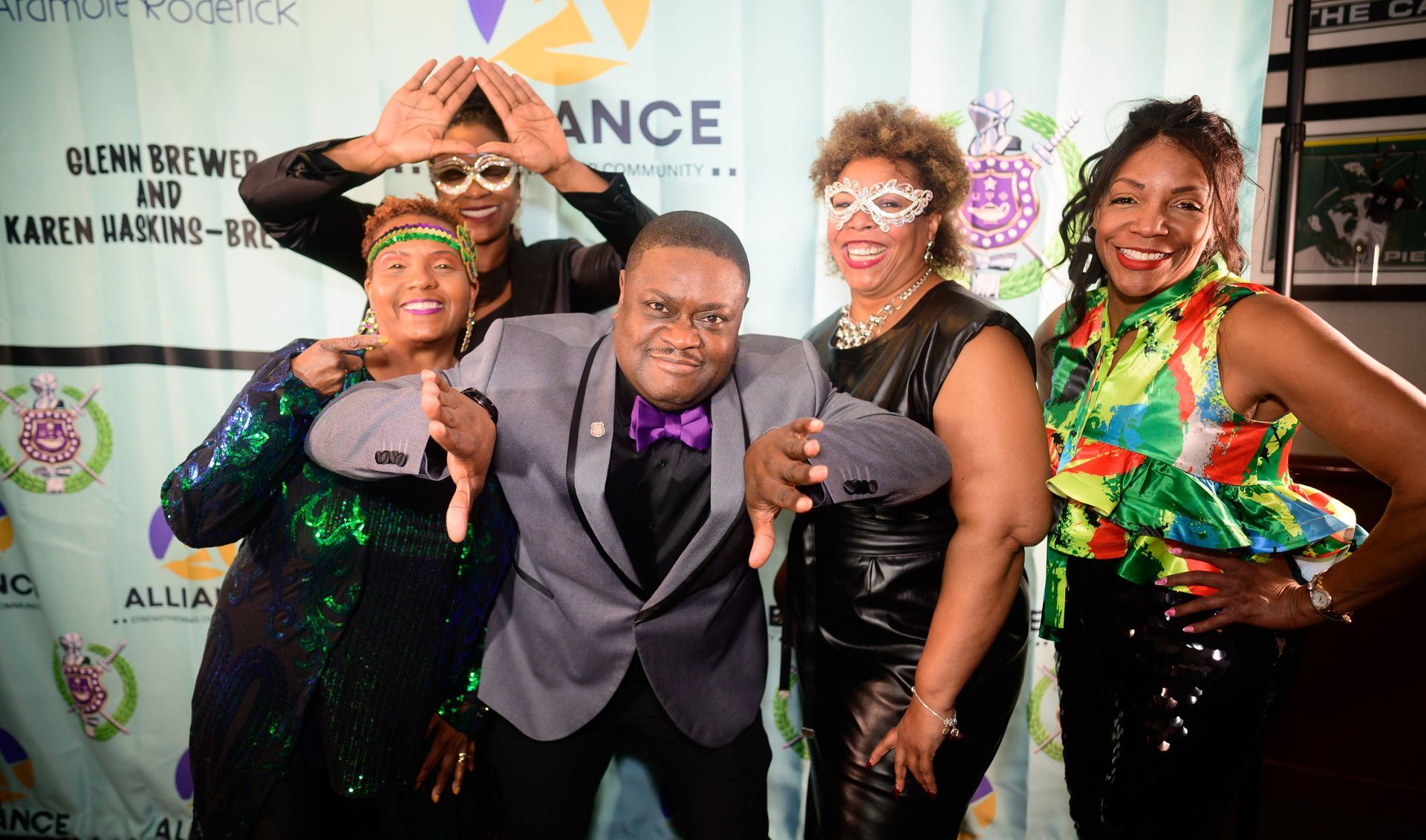 A group of people posing for a picture in front of a banner that says ance