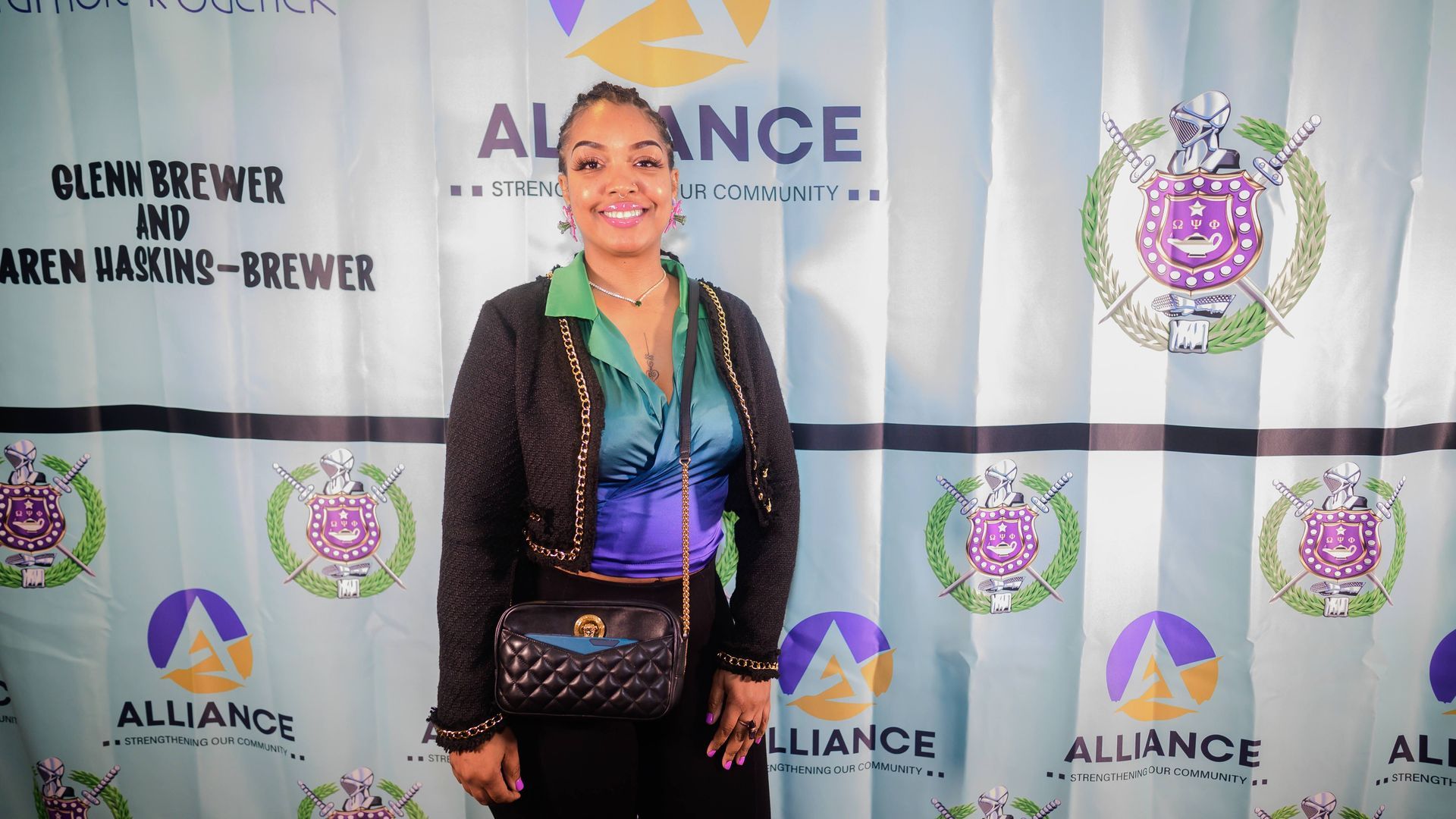 A woman is standing in front of a banner that says alliance