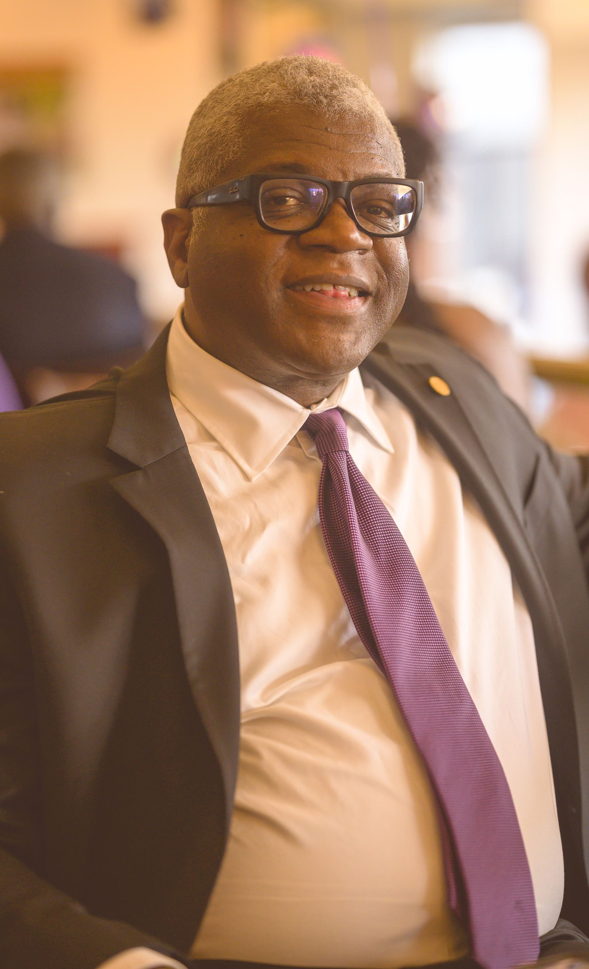 A man in a suit and tie is smiling for the camera.