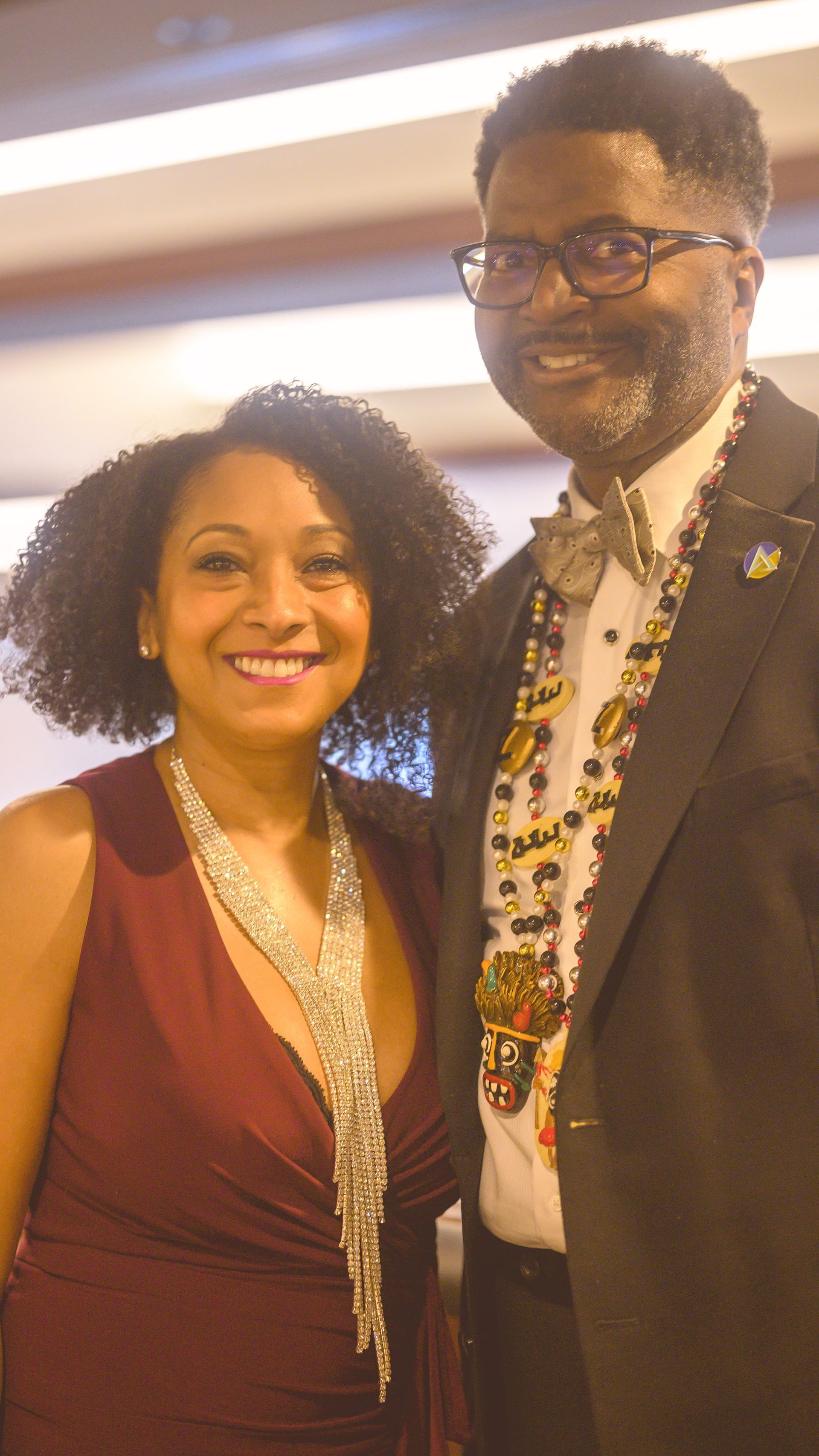 A man in a tuxedo and a woman in a dress are posing for a picture.