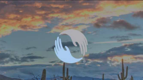 White circular logo over a desert sunset sky with clouds and cactus silhouettes