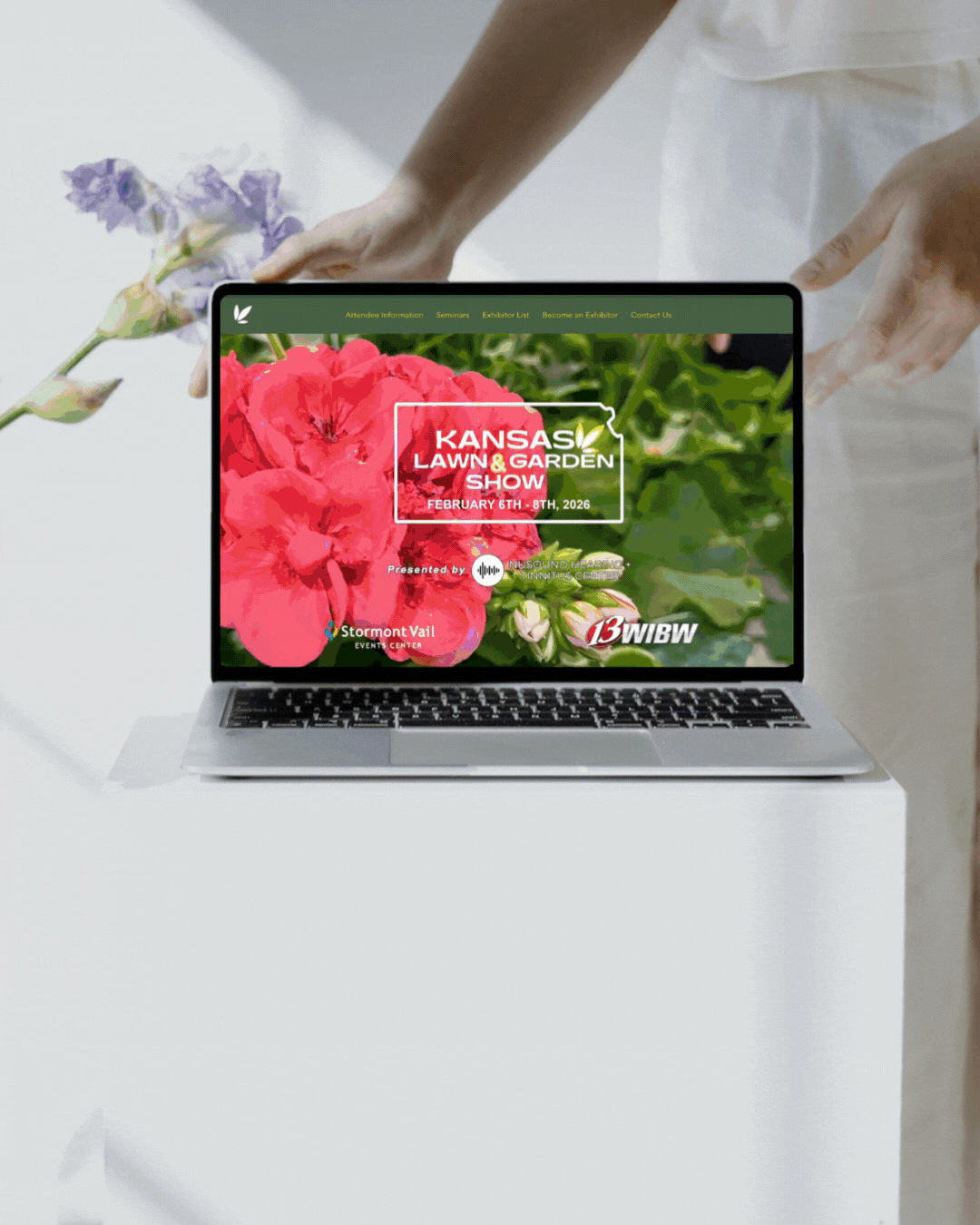 A laptop with a red flower on the screen is sitting on a table.