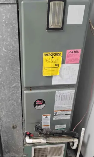 Gray HVAC unit with energy guide sticker, refrigerant type, and brand logo.